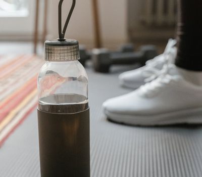 Close-up of a folded yoga mat and a water bottle.